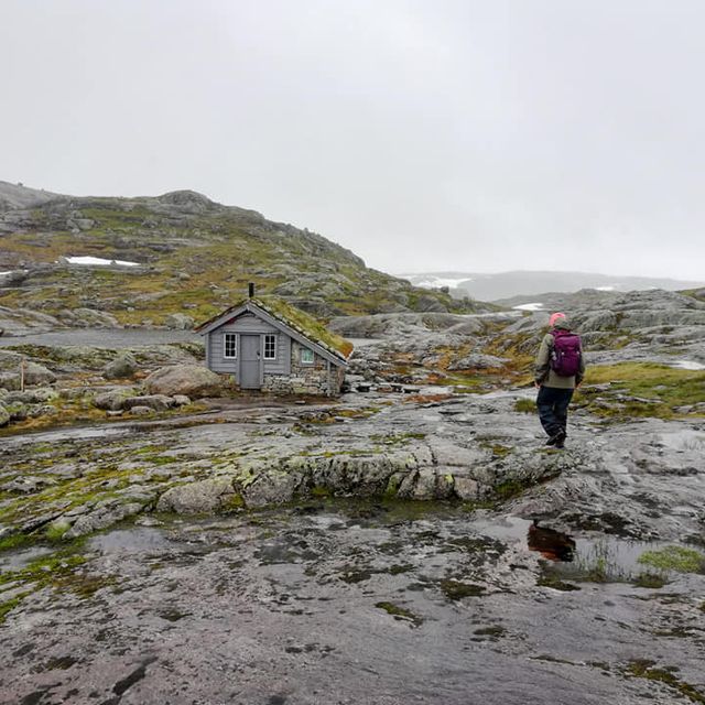 Person går mot fjellhytte